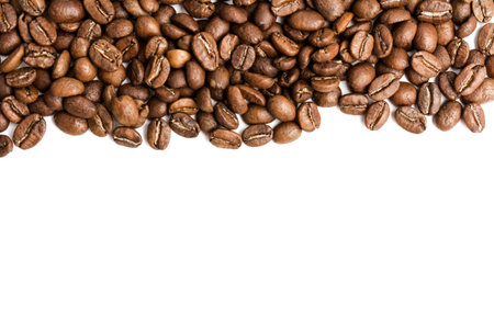 many scattered freshly roasted coffee beans on white background top view. empty space for the label....