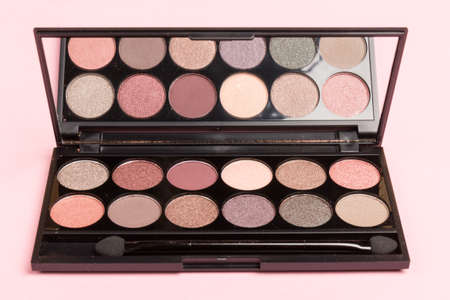 The concept of makeup and office dresscode. nude palette of shadows with beige, rose and brown shades on rose background top viewの写真素材