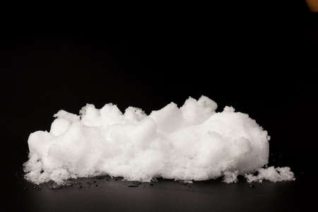 pile of white snow isolated on black background. The structure of snow and ice. Close-up.の写真素材