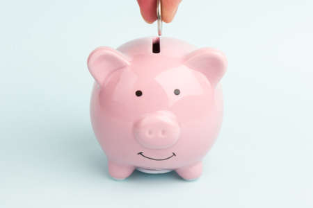 Piggy bank with coin on white background, space for text. Finance, saving money. Business to success and saving for retirement conceptの写真素材