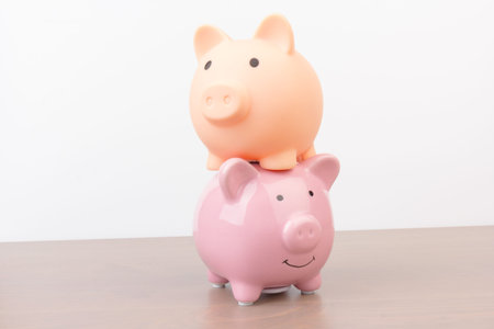 two pink Piggy bank on wooden background, space for text. Finance, saving money. Business to success...