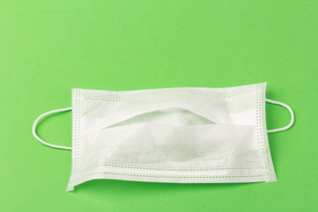 White medical mask isolated on blue background. Face mask protection against pollution, virus