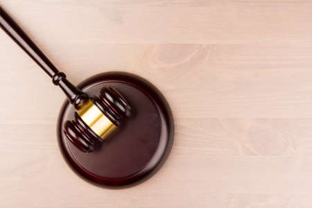 Brown wooden judges gavel on the table in close up. Wooden table. Space for text. Law and Justice themeの写真素材