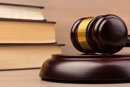 Brown wooden judges gavel on the table in close up. Wooden table, books. Space for text. Law and Justice themeの写真素材