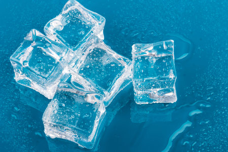 Pyramid of the melted ice cubes with drops.ice cubes and water drops close up on blue background