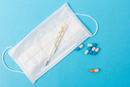 Blue and white capsules and orange whith white capsule pill on blue background. Copy space. Global...