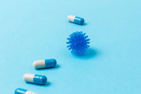 Blue and white capsules on blue background. Global healthcare concept. Antimicrobial capsule pills. Pharmaceutical industry.の写真素材