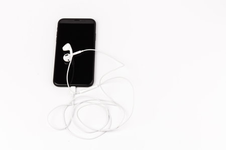 Headphone and phone on white background. Ready to listen to music.の写真素材