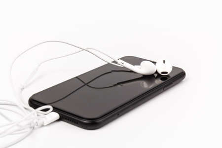 Headphone and phone on white background. Ready to listen to music.の写真素材