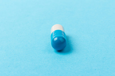 Blue and white capsules on blue background. Copy space. Global healthcare concept. Antimicrobial...