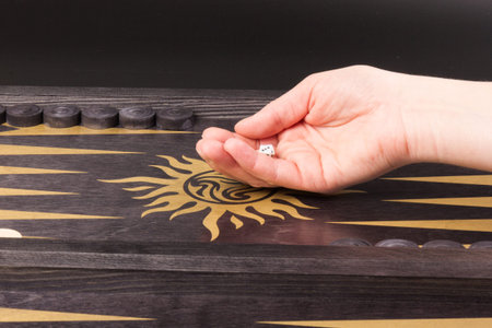Backgammon. Board game. White cubes and chips on a blackboard. Backgammon traditional oriental game,...