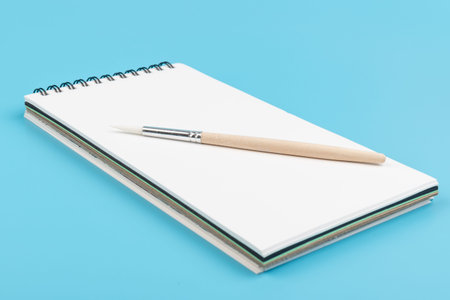 Back to school. Notepad whith brush on a blue background, painting set. School learning concept....