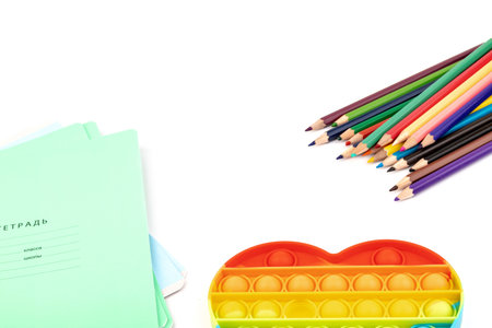Notebooks, toy popit and crayons - concept with space for text on the subject of school