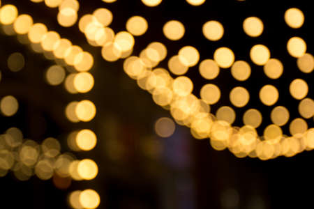 Blurred sparks from fire in front of black backgound. Christmas and New Year holidays concept. Defocused garland lights, Bokeh effect.の写真素材