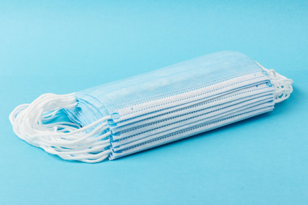 Prevent virus. Medical mask, Medical protective mask isolated on blue background. Disposable surgical face mask cover mouth and nose. Healthcare medical virus quarantine, hygiene conceptの写真素材