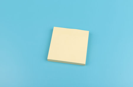 blank square yellow reminder paper notes on blue texture background.