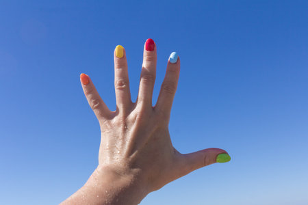 Colorful nail art on blue sky. Colorful nail polish. the concept of the summer restの写真素材