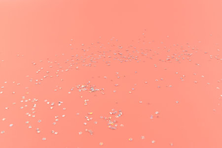 Glitter stars confetti on pink background in bright pastel colors. Elegant abstract background. Festive concept.の写真素材
