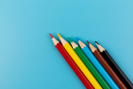 Composition with colored pencils on a bright blue background. top view. space for text.frame