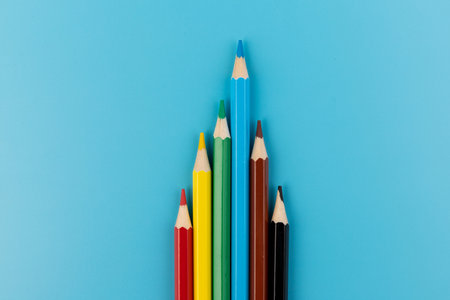 Composition with colored pencils on a bright blue background. top view. space for text.frame