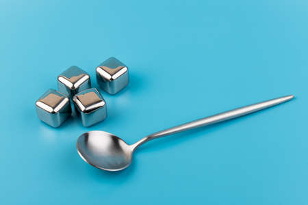 stainless steel ice cubes whiskey stones, isolated on blue background. Space for text.の写真素材
