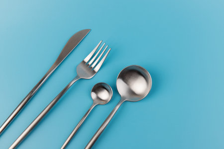 fork, knife, spoon, cutlery on blue background.
