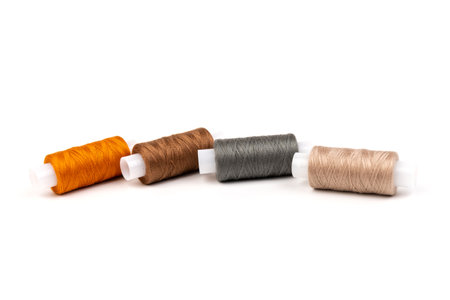 Sewing threads of different colors on reels on white background. Free space, close-up.の写真素材