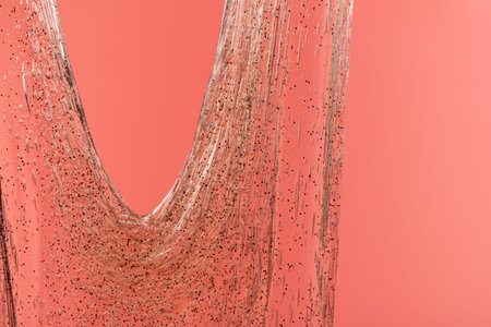 Glitter slime on pink background. Transparent toy. Glossy texture with girly colors of pink.