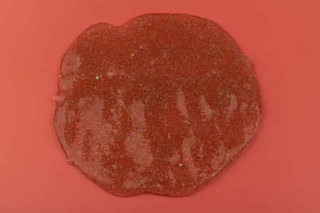 Glitter slime dripping on pink background. Transparent toy. Glossy texture with girly colors of pink.の写真素材