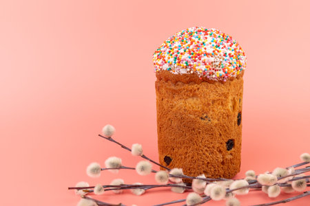Easter cakes with willow twigs on pink background. Easter holidays breakfast concept with copy...