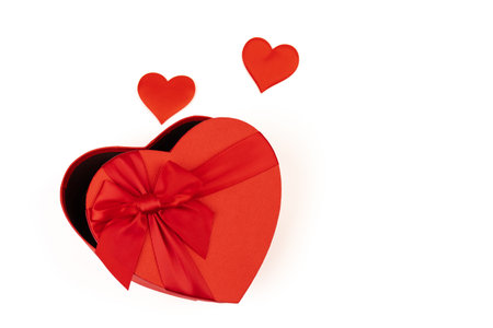 Red heart-shaped gift box with a red ribbon on white background. Happy Valentine's Day. Anniversary.の写真素材