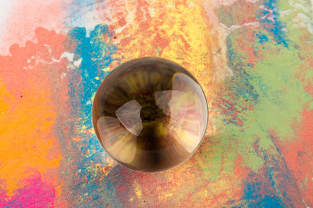 Crystal glass ball on bright color background, space for text.