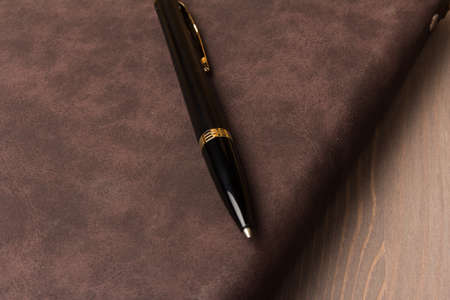 Top view mockup template with a pen and notebook laying on a wooden background.の写真素材