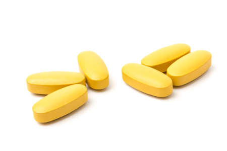 Yellow Multivitamin and mutimineral pills, nutritional Supplement on white background in close-upの写真素材