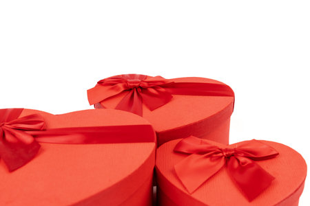Red heart-shaped gift box with a red ribbon on white background. Happy Valentine's Day. Anniversary.