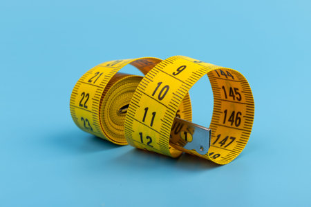 Yellow measuring tape on blue background. Space for text.