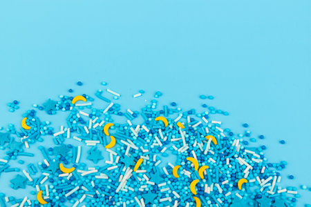Sprinkle with grains of desserts. Sweet confetti in the form of stars, moon on blue background. Design for holiday designs, party, birthday, invitation.の写真素材
