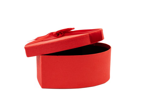 Red heart-shaped gift box with a red ribbon on white background. Happy Valentine's Day. Anniversary.