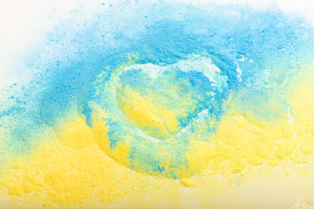 Ukrainian flag in the shape of a heart, the concept of peace in Ukraine. Powder paint Holi. yellow and blue.の写真素材