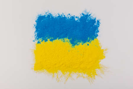 colorful Ukrainian flag yellow blue color holi paint powder explosion isolated on white background. russia ukraine conflict war freedom concept. Colored textured background.の写真素材