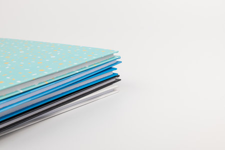 Pile of blue, black,white notebooks isolated on white backgroundの写真素材