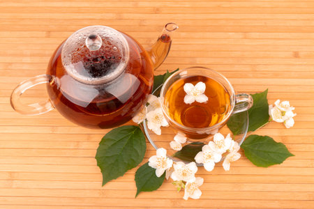 Cup of tea with jasmine, on bamboo mat, on bright backgroundの写真素材