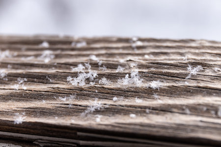 Christmas background with snowflakes on wooden texture.