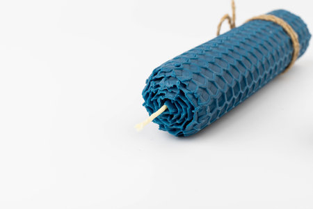 Blue beeswax honeycomb candle isolated on white. natural wax. On light background.の写真素材