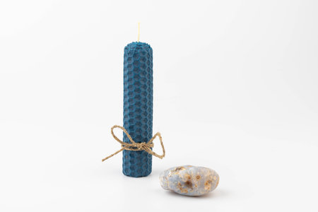 Blue beeswax honeycomb candle isolated on white. natural wax. On light background.の写真素材