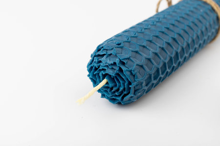 Blue beeswax honeycomb candle isolated on white. natural wax. On light background.の写真素材