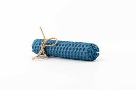 Blue beeswax honeycomb candle isolated on white. natural wax. On light background.の写真素材