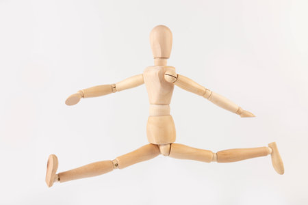 Wooden mannequin happy jump on white background. creative happiness concept.の写真素材