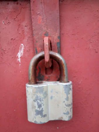 Old rusty vintage lock on a metal doorの写真素材