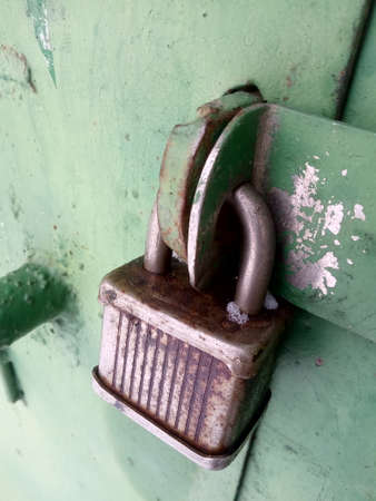 Old rusty vintage lock on a metal doorの写真素材